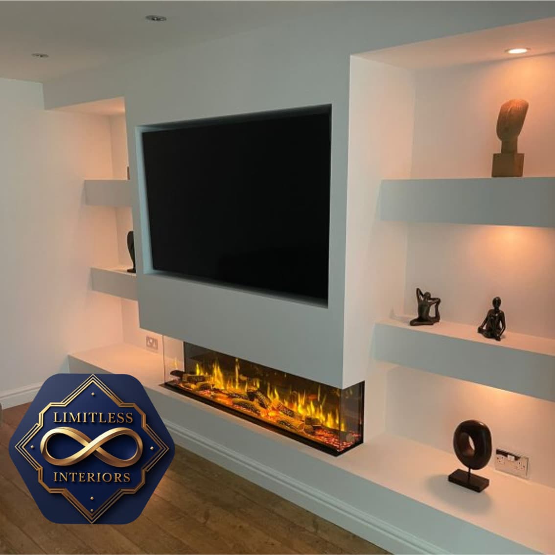 Modern white media wall with a recessed TV, linear electric fireplace, and illuminated display shelves.